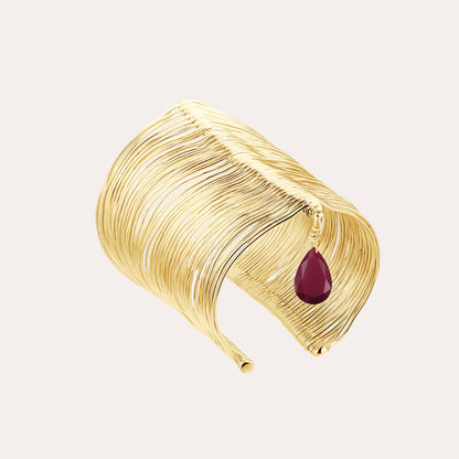 RIPPLE GOLD BANGLE WITH A BURGUNDY STONE